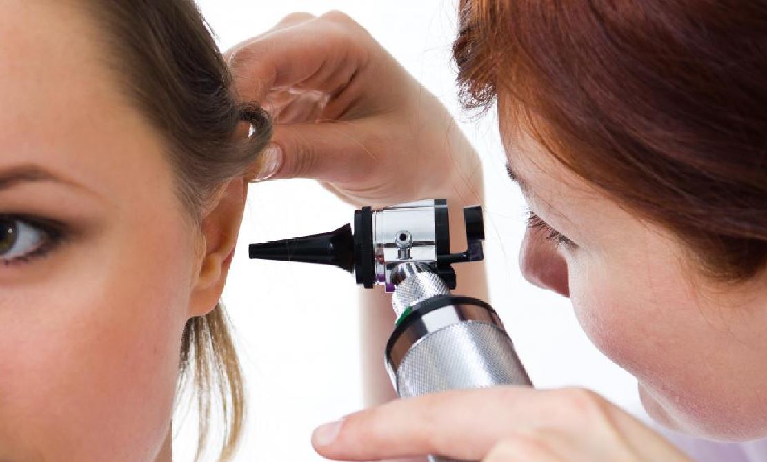 Shauna_Land_Heritage_Hearing_Aid_Solutions_Looking_Into_Ear_Of_Patient