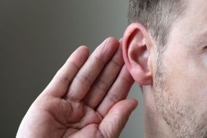 man holding hand to his ear