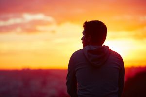 A man looks at the sunrise.