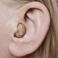 Picture of an in-the-canal hearing aid (ITC), worn by a woman. 