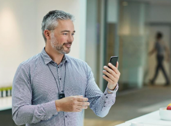 A man who has a cochlear implant video chats with a friend.