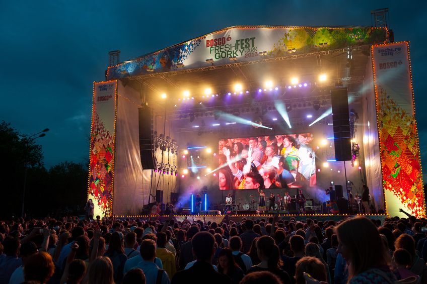 A loud outdoor summer concert with massive speakers.