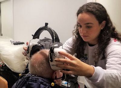 A volunteer places testing equipment on a refugee from the Ukraine.
