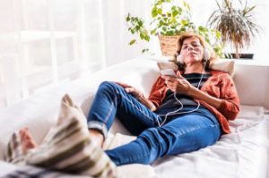 A woman listens to an audiobook at home.