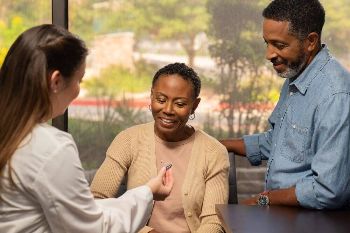 A woman receives new hearing aids at a hearing care appointment with an audiologist.