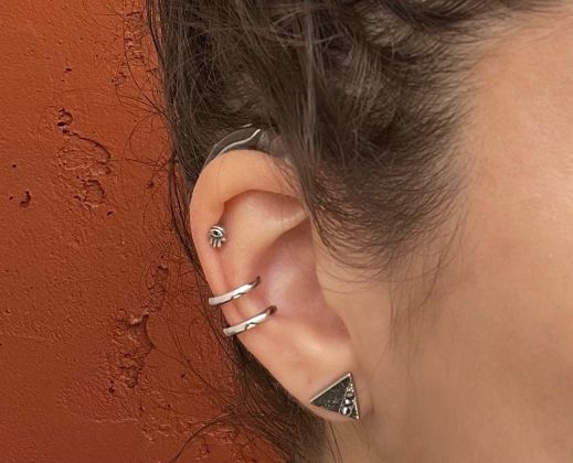 A woman wears a hearing aid cuff from DeafMetal, a jewelry company for hearing aids and cochlear implants.