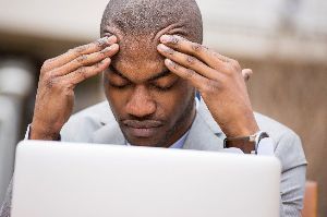 A man grabs his forehead.
