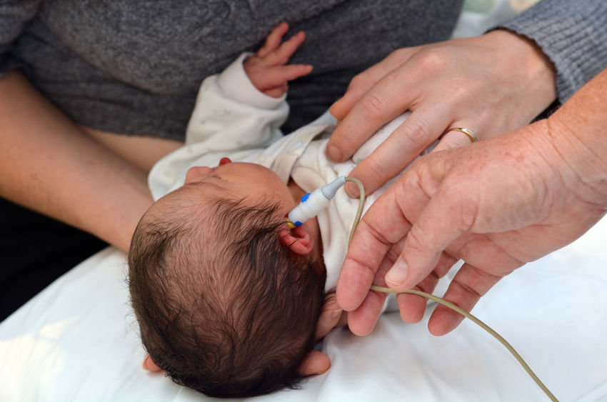 A newborn receives hearing screening in the hospital. 