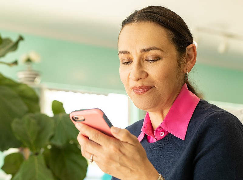 A woman plays a game on her iPhone.