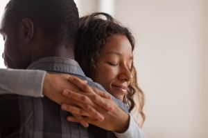 A woman hugs a loved one. 